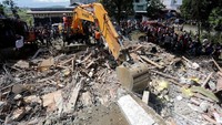 Ekskavator mencari korban di reruntuhan bangunan di Lueng Putu. Antara Foto/Irwansyah Putra/Reuters.