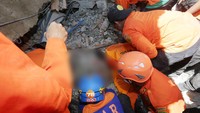 Tim SAR mencari korban di reruntuhan bangunan di Lueng Putu. Antara Foto/Irwansyah Putra/Reuters.