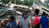 Warga berkerumun di depan bangunan yang telah rata dengan tanah. Zian Muttaqien/AFP/detikFoto.