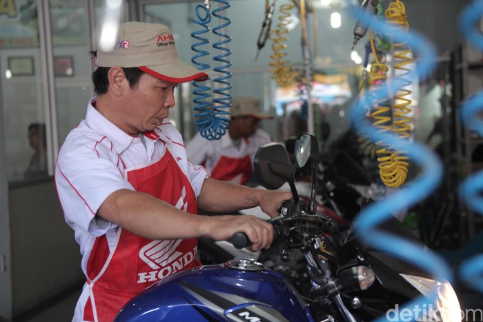 Mekanik Honda memeriksa sebuah motor di diler