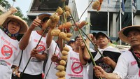 Sejumlah petani terlihat menggantung beberapa kentang dan wortel sebagai simbol tuntutan mereka.