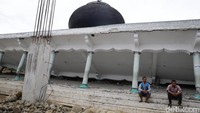 Dua orang warga duduk di depan masjid yang ambruk akibat gempa.