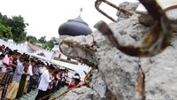 Warga saat menunaikan ibadah salat Jumat di sekitar reruntuhan masjid.