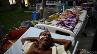 Seorang pasien tertidur dengan perban tertempel kepalanya.