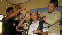 Deputi IV bidang SDM, IPTEK dan Budaya Maritim Kemenko Maritim Safri Burhanuddin memasangkan alat selam scuba diving saat pengenalan budaya maritim kepada siswa-siswi SD  di Dinas Pendidikan, Pemuda dan Olahraga, Labuan Bajo, Jumat (9/12/2016).