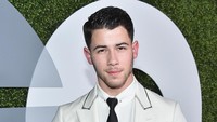 Ia tampil necis dengan setelan jas putih dan celana hitam. Mike Windle/Getty Images for GQ/detikFoto.