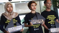 Sejumlah peserta aksi kompak mengenakan kaos hitam bertuliskan Hentikan Perdagangan Manusia Dan Perbudakan di Laut.