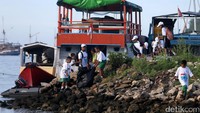 Para siswa memunguti sampah di sekitar pantai.