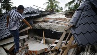 Seorang warga melihat kondisi rumahnya yang telah rata dengan tanah.