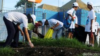Sampah yang berserakan dimasukkan ke kantong plastik besar.