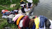 Beberapa warga tampak menyikat pakaiannya.