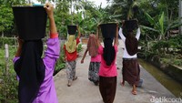 Usai mengambil air, sejumlah anak harus berjalan lagi untuk kembali ke posko darurat.