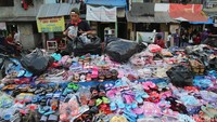 Pedagang menata sendal-sendal yang akan dijual.