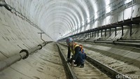 Seorang petugas tengah memeriksa titik jalur rel MRT.