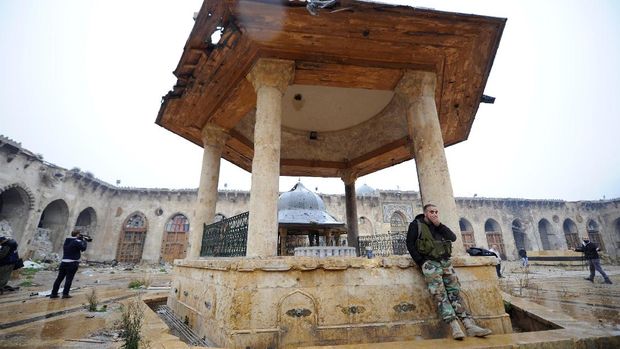 Tentara pro-pemerintah Suriah memeriksa kerusakan di dalam Masjid Umayyad