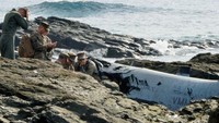 Tentara AS berkumpul di dekat puing MV-22 Osprey sesaat setelah jatuh. Semua awak selamat dan hanya mengalami luka-luka. Otoritas setempat masih menyelidiki penyebab pasti jatuhnya pesawat. REUTERS/Kyodo.