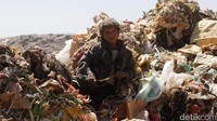 Seorang bocah tengah duduk dalam tumpukan sampah di sebuah tempat pembuangan kahir (TPA) di pinggiran Kota Sanaa, Yaman. REUTERS/Mohamed al-Sayaghi.
