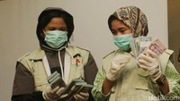 Petugas KPK terlihat memegang barang bukti uang senilai Rp 2 miliar.