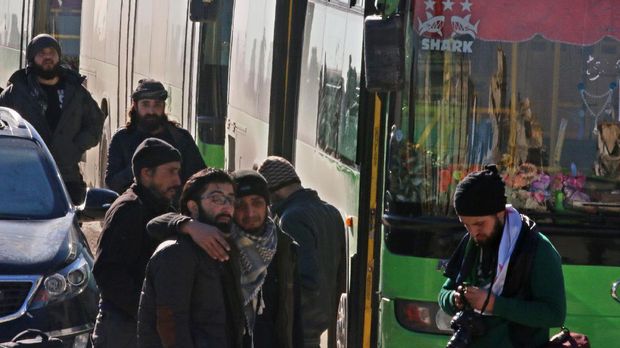 Warga Aleppo menunggu di luar bus yang mengevakuasi mereka