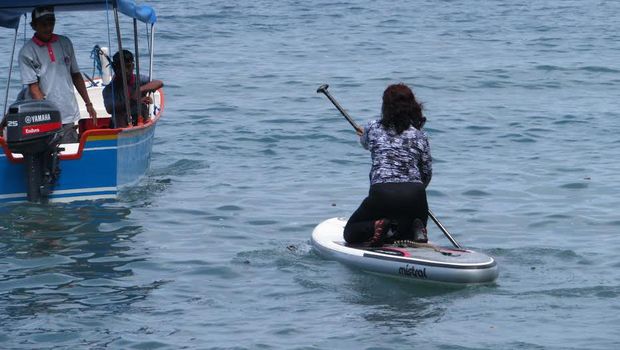 Menteri Susi mendayung kano menuju ke tengah laut.