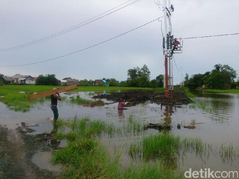 Hanyutkan Tiang  Listrik  Lewat Sungai PLN Terangi Desa 