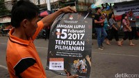 Warga membaca poster yang dibagikan KPUD saat sosialisasi Pilkada DKI Jakarta 2017.