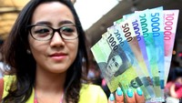 Seorang warga menunjukkan rupiah baru pecahan kertas.