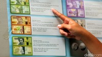 Poster berisi pengumuman diterbitkannya rupiah baru terpampang di lokasi penukaran. Poster itu bergambar desain baru rupiah.