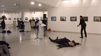 Andrey Karlov tewas di tempat. Sementara para pengunjung tampak berlarian keluar ruangan. Stringer/AFP.