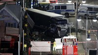 Terlihat bagian depan truk berwarna hitam berada di sisi jalan raya. Sementara lori atau badan truk berada di bagian pasar di atas trotoar.Pawel Kopczynski/Reuters/detikFoto.