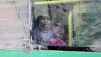 Seorang bocah tak kuasa menahan rasa haru saat berhasil dievakuasi ke dalam bus berisi pejuang dari Aleppo timur dan keluarga mereka meninggalkan sektor yang dikuasai pemberontak dari kota Suriah pada hari Minggu (18/12) waktu setempat. REUTERS/Abdalrhman Ismail.