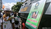 Massa menyandarkan poster tuntutan di mobil taktis Polri.