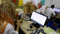 Petugas PT. Pos Indonesia mengecek barang yang akan dikirim.