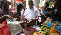 Anies melihat kupon yang dibagikan ke warga untuk membeli sembako murah dalam kampanye Anies-Sandi.