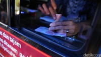 Seorang petugas nampak menghitung sejumlah uang.