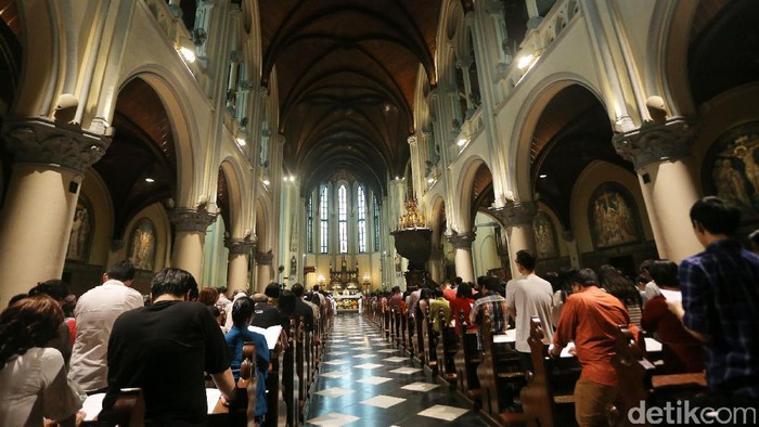 Umat Kristiani mengikuti misa malam Natal di Gereja Katedral, Jakarta. Misa Natal ini bertema 