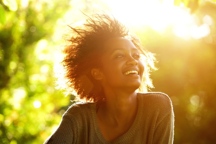 Close up portrait of a beautiful african american woman smiling with sunset
