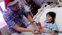 Head Business Development Siloam Hospitals Lippo Village Alexander Mutak memberikan hadiah Natal kepada seorang pasien.