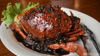 Kepiting merah seberat 5 ons tersaji dengan siraman bumbu hitam. Teksturnya agak lengket dengan sensasi rasa pedas yang enak dinikmati dengan nasi hangat.