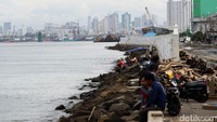 Warga terlihat asyik berbincang dengan latar belakang pelabuhan.