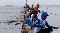 Sejumlah warga terlihat asyik memancing di kawasan Pelabuhan Muara Baru, Jakarta Utara, Selasa (27/12/2016).
