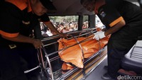 Jenazah dimasukan ke dalam ambulans.