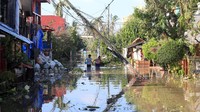 Dua orang warga tengah menerobos banjir akibat dari dahsyatnya dampak topan Nock-Ten di Naboa, Camarines sur, wilayah Bicol, Filipina, Selasa (27/12/2016) waktu setempat. REUTERS/Romeo Ranoco.