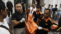 Polisi mengevakuasi kelima jenazah dari dalam rumah.