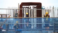 Para pekerja sedang memasang tiang pemancang untuk pondasi MRT.
