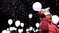 Ya, mereka terlihat melepaskan ratusan balon berwarna putih ke langit. REUTERS/Issei Kato.