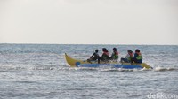 Sambil menunggu sunset, wisatawan bisa mencoba watersport. Tampak wisatawan sedang naik banana boat (Fitraya/detikTravel)