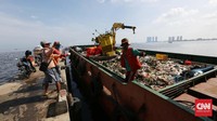 Petugas kebersihan juga memindahkan sampah-sampah dari pinggir laut ke dalam kapal sampah di Pelabuhan Kali Adem, Jakarta Utara, Senin,(2/1/2017). CNN Indonesia/Safir Makki