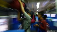Penumpang menurunkan barang bawaan mereka.