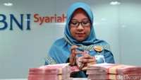 Petugas sedang menghitung uang di BNI Syariah, Jakarta, Selasa (3/1/2017).